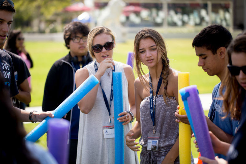 Students holding pool noodles